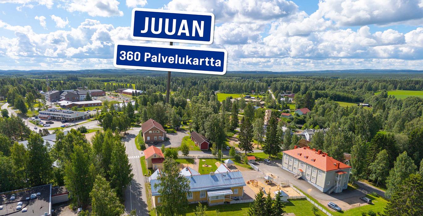 Ilmakuva Juuan keskustasta aurinkoisena p&auml;iv&auml;n&auml;, jota ymp&auml;r&ouml;i laaja mets&auml;alue. Kuvan yll&auml; on sininen kyltti tekstill&auml; "JUUAN 360 Palvelukartta".