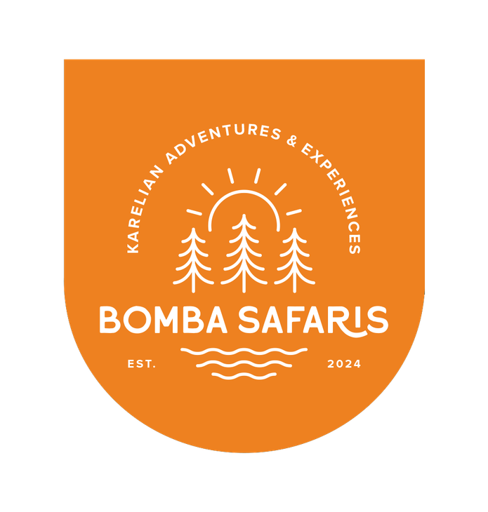 Bomba Safaris -yrityksen logo, jossa on oranssi, kilven muotoinen tausta. Sen sis&auml;lle on piirretty valkoisin viivoin kolme kuusta, nouseva aurinko ja aaltoilevaa vett&auml;. Kuvion yl&auml;puolella kaareutuu teksti &rdquo;KARELIAN ADVENTURES &amp; EXPERIENCES&rdquo;, keskell&auml; lukee &rdquo;BOMBA SAFARIS&rdquo; ja alhaalla &rdquo;EST. 2024&rdquo;.