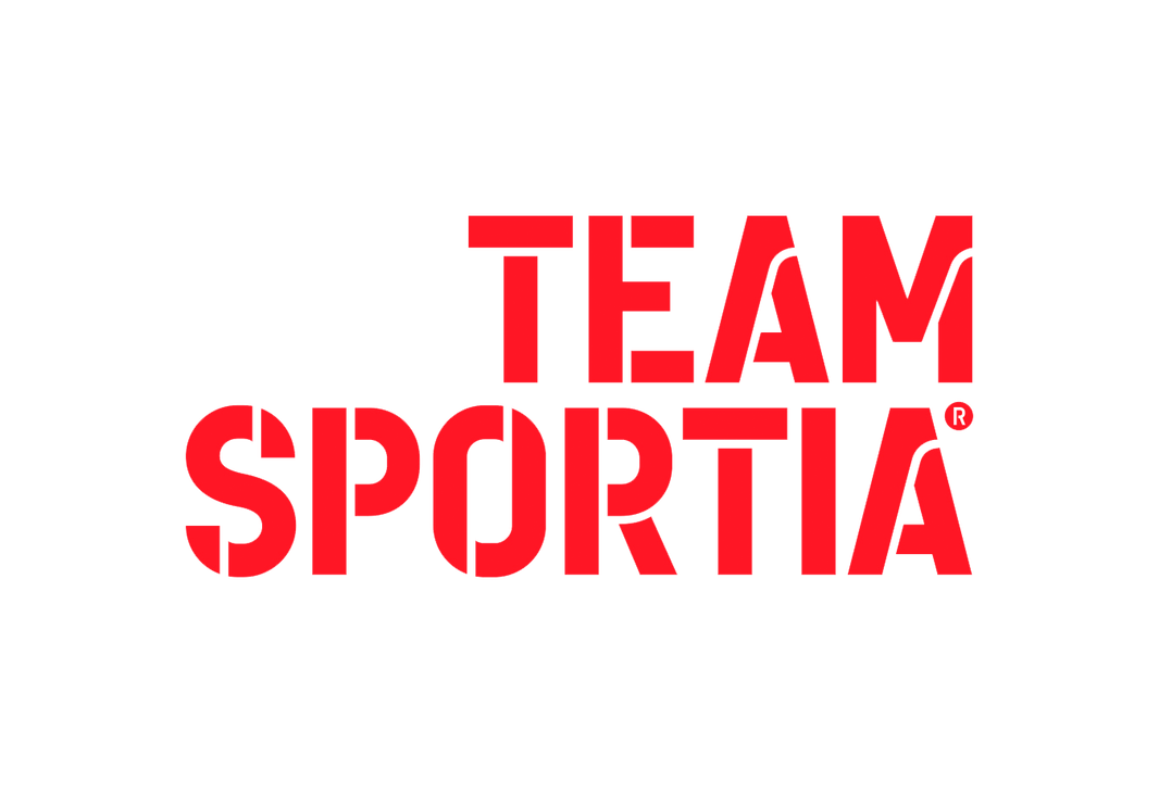Team Sportia -kauppaketjun logo. Logossa on kaksi riviä suurta, paksulla ja modernilla, urheilullisella fontilla kirjoitettua tekstiä. Teksti on kirkkaan punainen ja siinä on tyyliteltyjä leikkauksia kirjaimissa. Ylärivillä lukee "TEAM" ja alarivillä, suuremmalla fontilla, "SPORTIA". Logo on valkoisella taustalla.