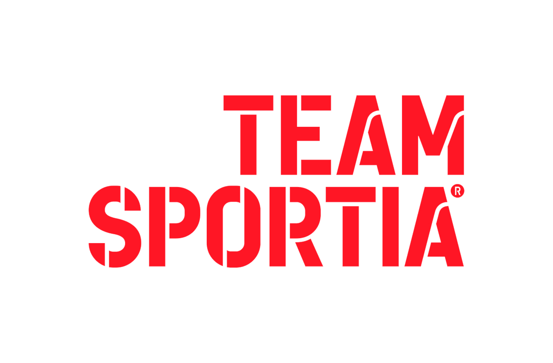 Team Sportia -kauppaketjun logo. Logossa on kaksi riviä suurta, paksulla ja modernilla, urheilullisella fontilla kirjoitettua tekstiä. Teksti on kirkkaan punainen ja siinä on tyyliteltyjä leikkauksia kirjaimissa. Ylärivillä lukee "TEAM" ja alarivillä, suuremmalla fontilla, "SPORTIA". Logo on valkoisella taustalla.