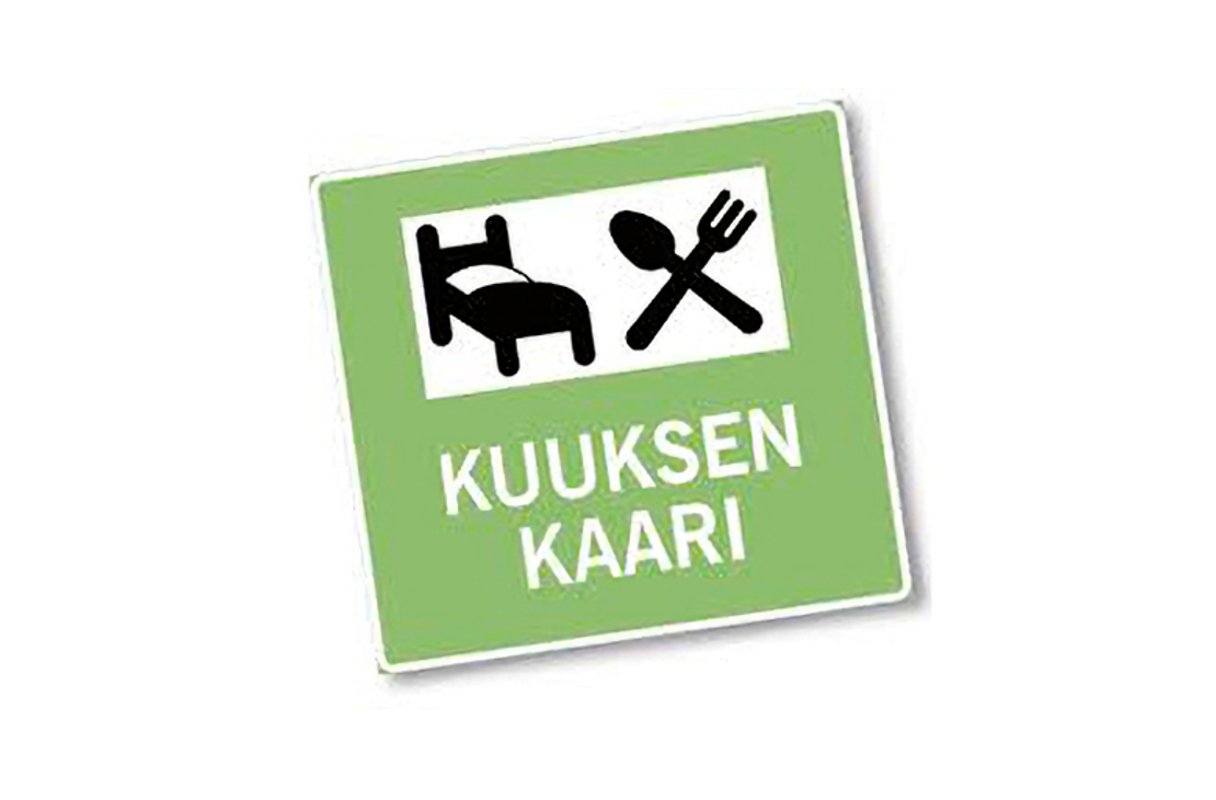 Kuuksen Kaari -palvelun liikennemerkkimäinen logo. Logo on vaaleanvihreä neliö, jossa on pyöristetyt kulmat ja valkoinen reunus. Yläosassa on valkoinen palkki, jonka sisällä on kaksi mustaa symbolia: sänky (majoitus) ja ristikkäin asetetut lusikka ja haarukka (ruokailu). Alaosassa on valkoisella, isolla tekstillä kaksi riviä: "KUUKSEN" ja "KAARI".