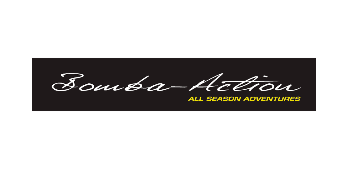 Bomba-Action All Season Adventures -yrityksen logo. Logossa on musta vaakasuora palkki. Palkin yläosassa lukee valkoisella, kursivoidulla ja käsinkirjoitetun näköisellä fontilla teksti "Bomba-Action". Sen alapuolella on pienemmällä, keltaisella, isoin kirjaimin kirjoitettu teksti "ALL SEASON ADVENTURES". Logo on sijoitettu valkoiselle taustalle.