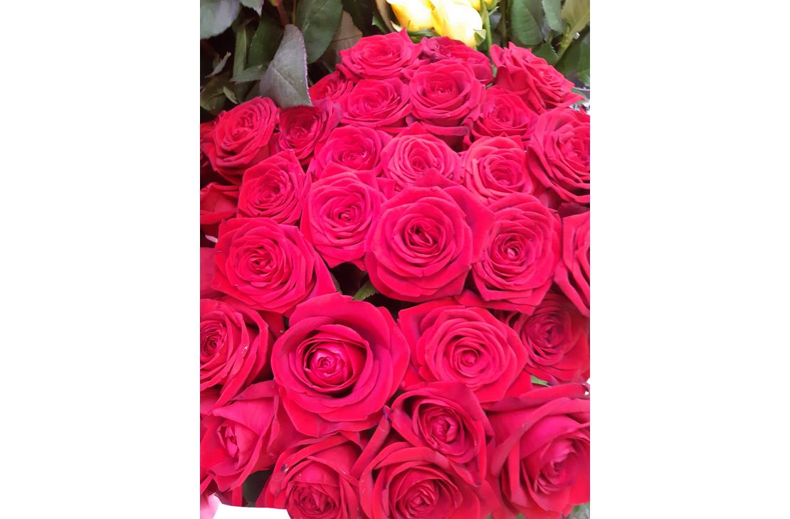 L&auml;hikuva Kukkakauppa Kein&auml;nen KY:n myym&auml;st&auml; suuresta, tiiviist&auml; punaisesta ruusukimpusta. Ruusut ovat avautuneita ja niiss&auml; on tummanpunainen s&auml;vy. Kimpun yl&auml;osassa n&auml;kyy pieni&auml; vihreit&auml; lehti&auml; ja taustalla erottuu himme&auml;sti muutama keltainen kukka.