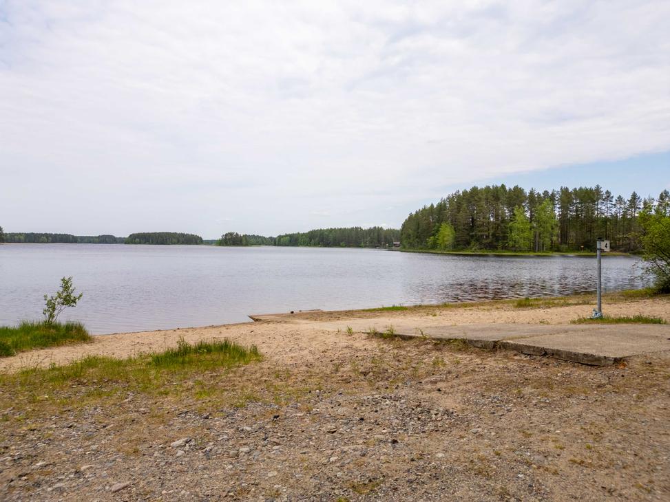 Soraikkoranta ja veneenlaskuluiska, joilta avautuu näkymä tyynelle järvelle. Oikealla on kylttitolppa, jossa näkyy numero 4, ja taustalla kohoaa vihreä havumetsä.