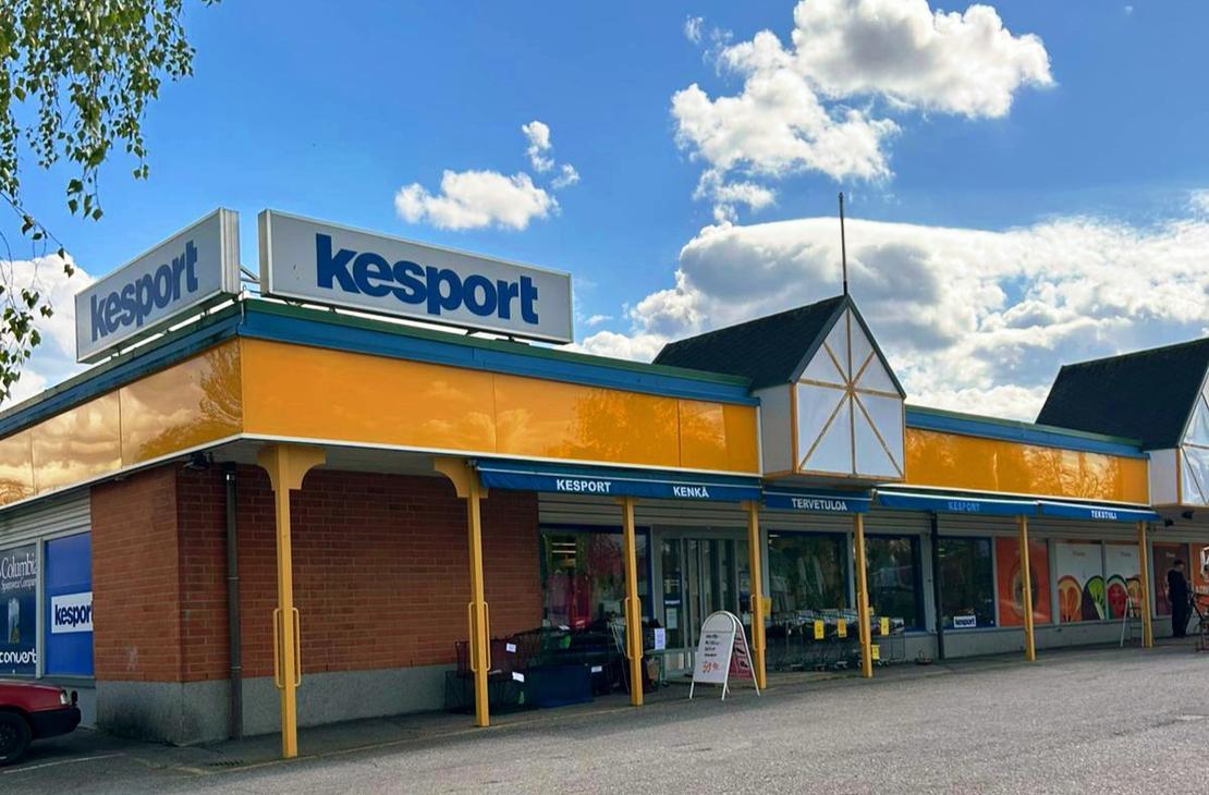 Kesport-urheilukaupan liikerakennus aurinkoisena päivänä. Rakennuksessa on keltainen julkisivu, sininen reunus ja katolla suuret Kesport-kyltit.