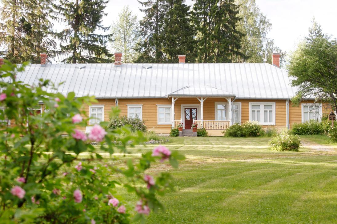Möhkön ruukkimuseon pitkä, keltainen puurakennus, jonka edessä on laaja nurmikko ja kukkivia pensasruusuja. Rakennuksessa on valkoiset ikkunankarmit, harmaa peltikatto ja pieni katettu kuisti.