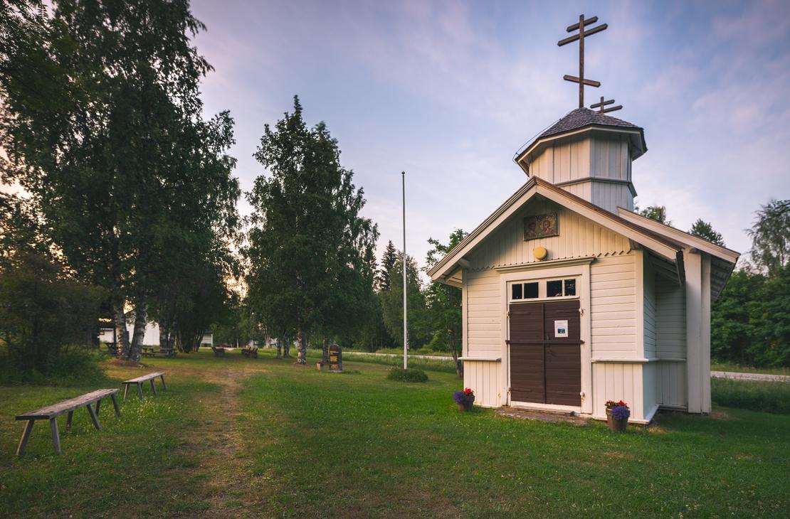 Pieni, punamultainen, perinteinen puurakennus, joka on Hattuvaaran tsasouna (ortodoksinen kappeli), harjakattoineen ja pienine ikkunoineen. Tsasouna sijaitsee m&auml;ntymets&auml;n reunustamalla hiekka- tai soratiell&auml;.
