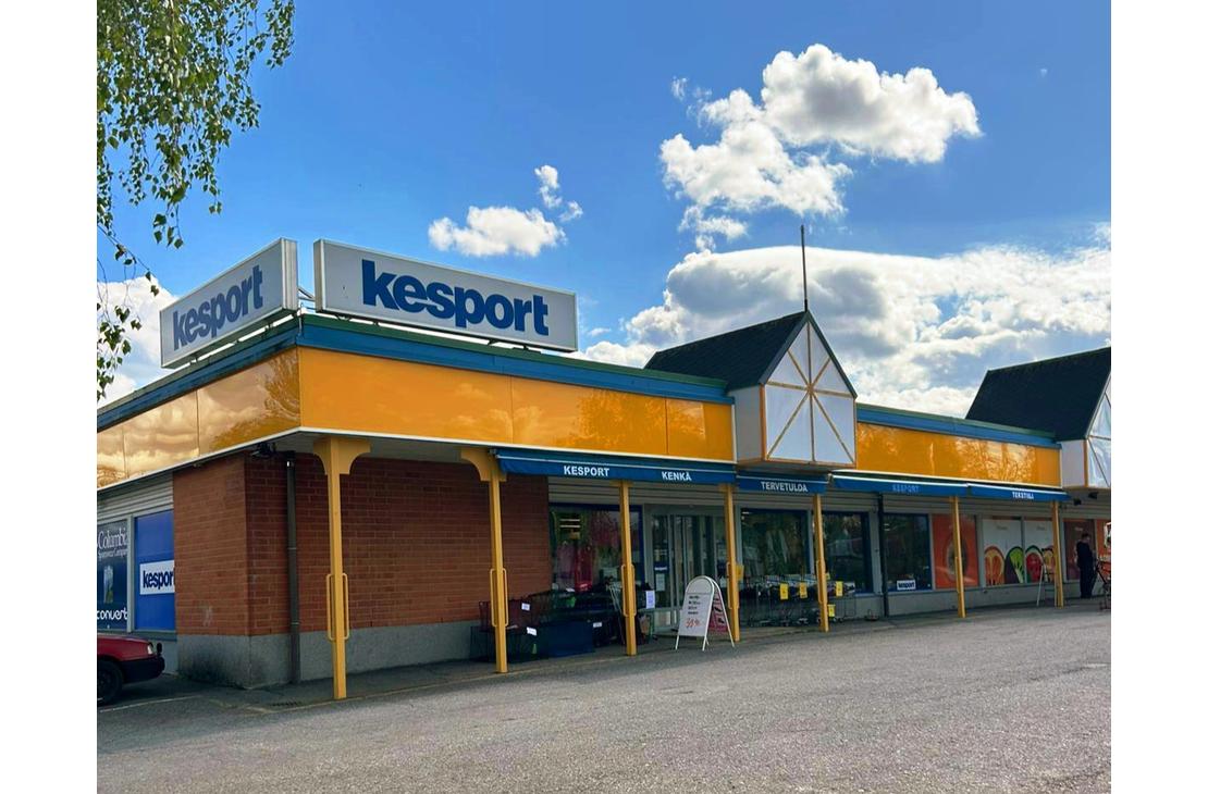 Kesport-urheilukaupan liikerakennus aurinkoisena päivänä. Rakennuksessa on keltainen julkisivu, sininen reunus ja katolla suuret Kesport-kyltit.