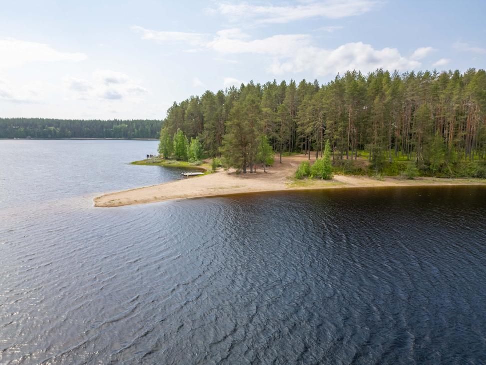 Ilmakuva järveen työntyvästä kapenevasta hiekkasärkystä, jota ympäröi kirkas ja tumma vesi. Särkän tyvellä kasvava mäntymetsä rehottaa vihreänä.