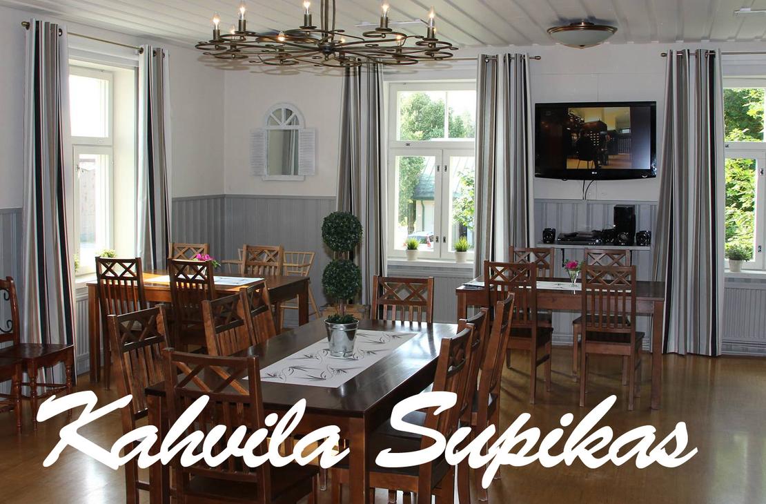 Kuva esittää Kahvila Supikkaan sisätiloja. Tila on valoisa ja siinä on useita suuria ikkunoita harmailla verhoilla. Seinät ovat kaksiväriset: alaosa on harmaa ja yläosa valkoinen. Huoneessa on useita puisia pöytiä ja tuoleja, ja pöydillä on valkoiset liinat. Oikealla on seinällä taulutelevisio. Kuvan alaosassa on suuri, valkoisella, kursivoidulla fontilla teksti "Kahvila Supikas".